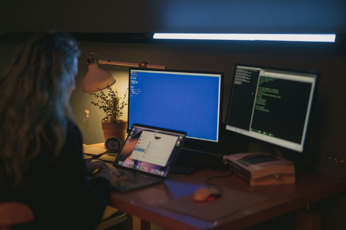 Woman working at home office desk reviewing security and account settings