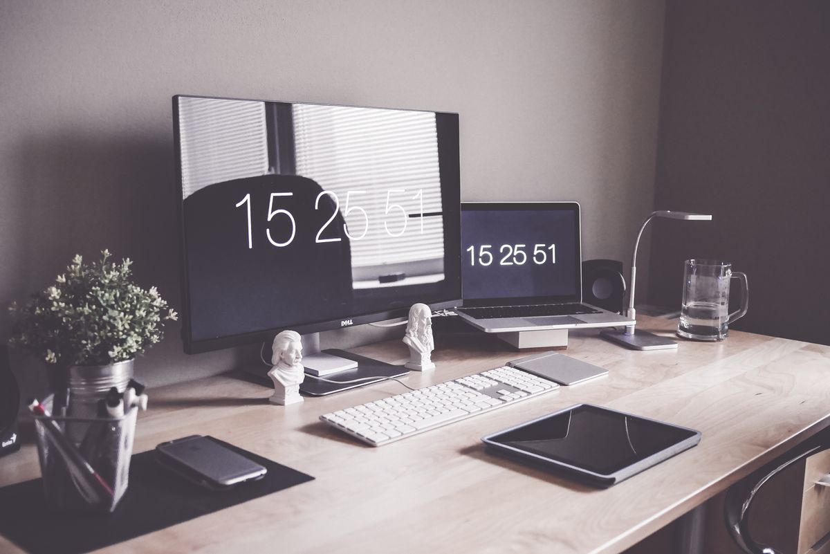 A tidy desk with a laptop and monitor set up for work