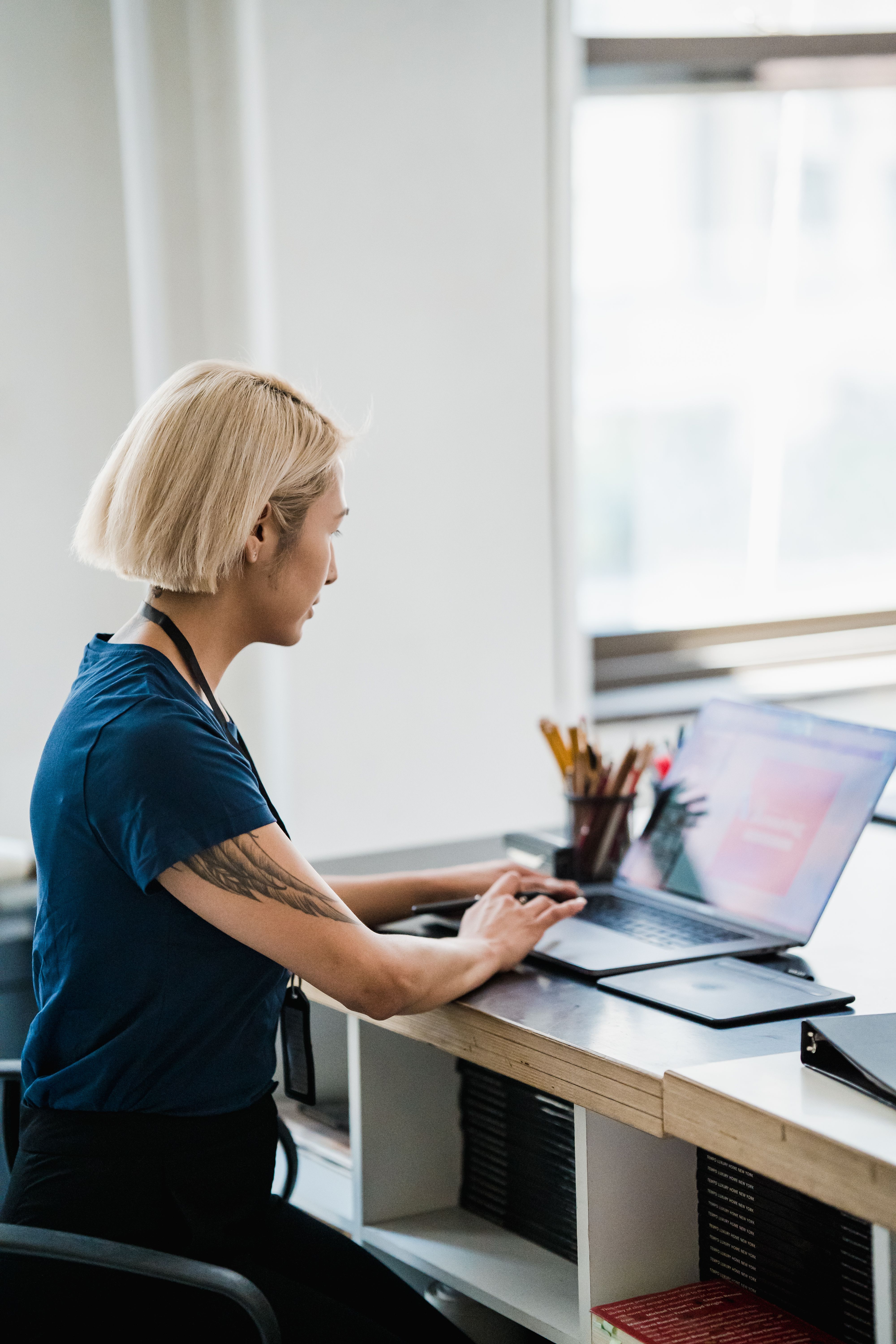 A professional working at a laptop in an office, reviewing a task on screen