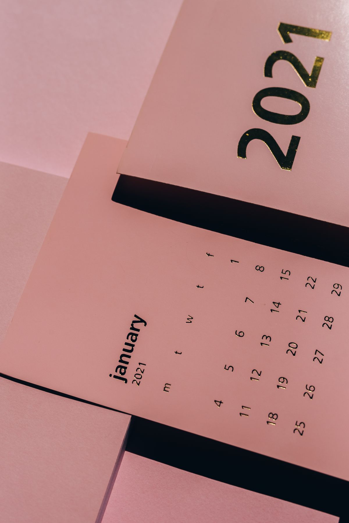 Paper calendars laid out on a desk showing weekly dates, illustrating the recurring schedule a standing bot plan follows