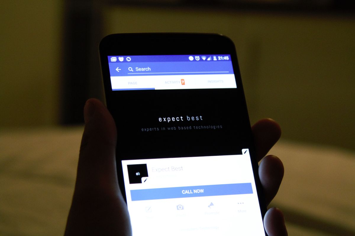 Close-up of a hand holding a smartphone, the way most bot reports actually get read — a short note on a phone screen, not a dashboard