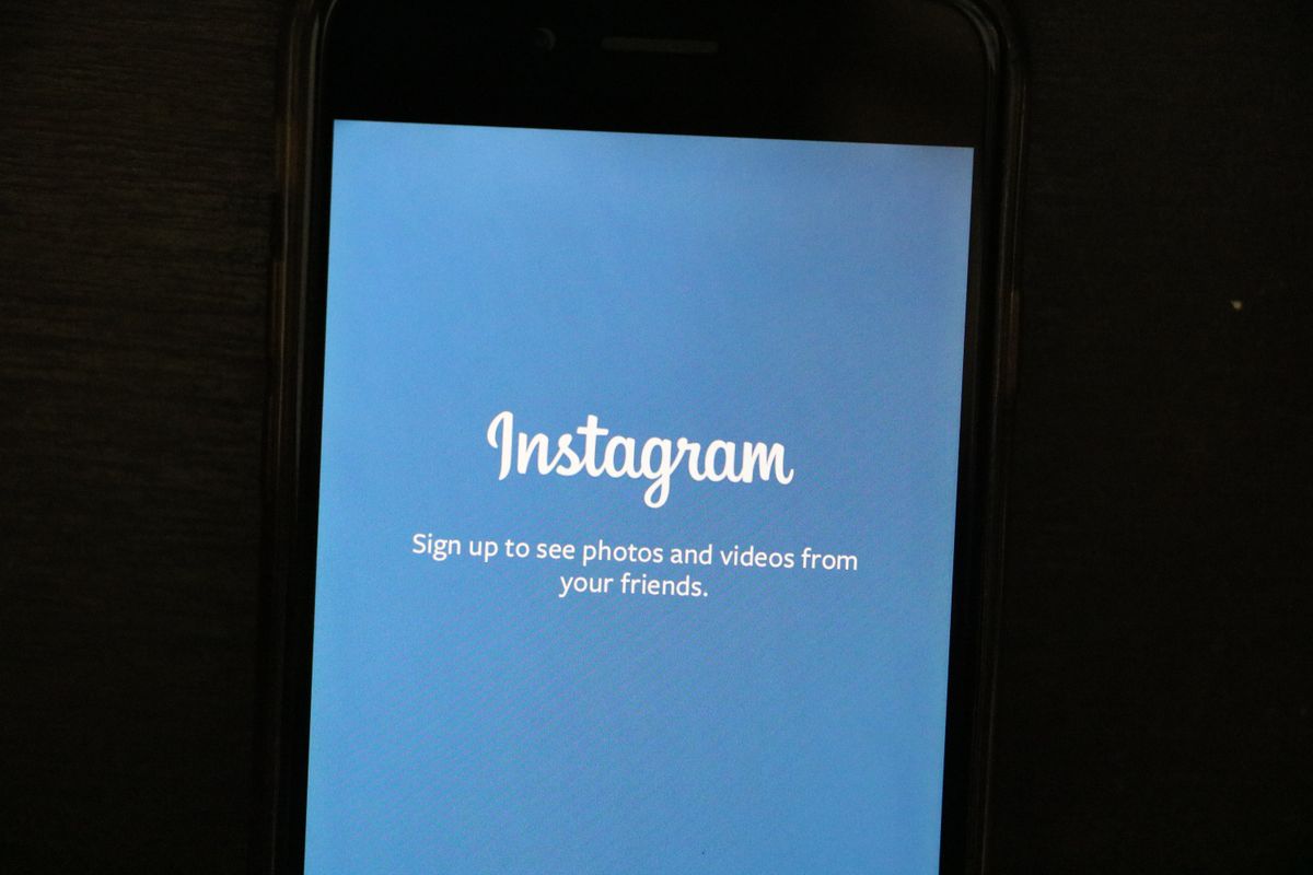 A smartphone screen displaying the Instagram app icon and sign-up screen, representing the app where Meta plans to test its Hatch AI shopping agent