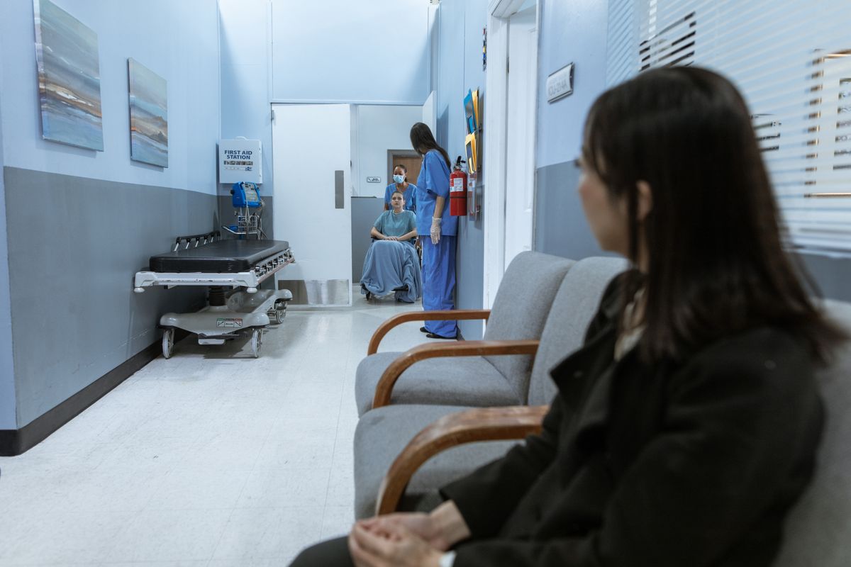 A person sitting and waiting in a modern waiting room, representing the position of someone deciding whether to wait for a not-yet-released AI agent feature