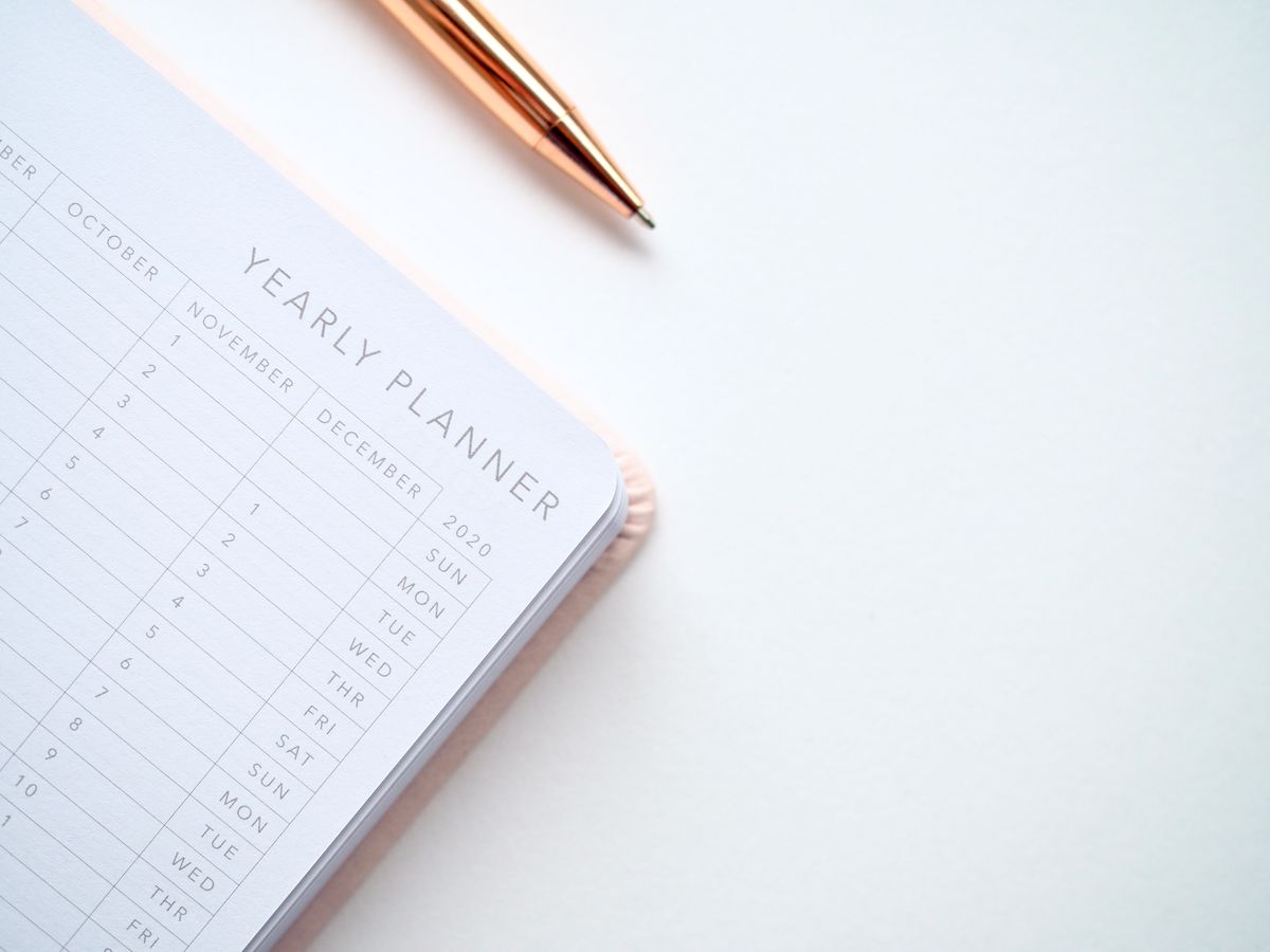 A yearly planner open on a desk next to a pen, representing the weeks between an announced billing change and its planned effective date